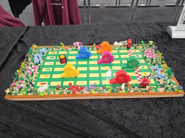 Ein Mensch-ärgere-dich-nicht-Spielbrett, komplett aus LEGO-Steinen gebaut, mit Blumenrand